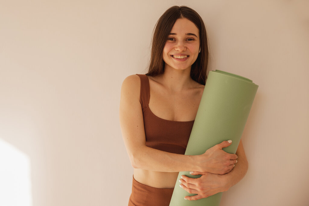 rsz_happy-caucasian-young-girl-holding-yoga-mat-smiling-camera-beige-background-pretty-woman-trainer-sports-tight-clothes-healthy-lifestyle-concept